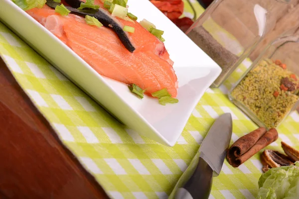 Filete de salmón fresco en plato blanco. cuchillo, pimiento rojo, canela y limón — Foto de Stock