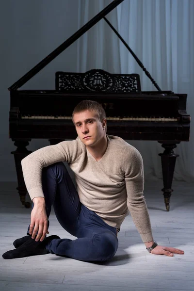 Mladý muž a piano — Stock fotografie
