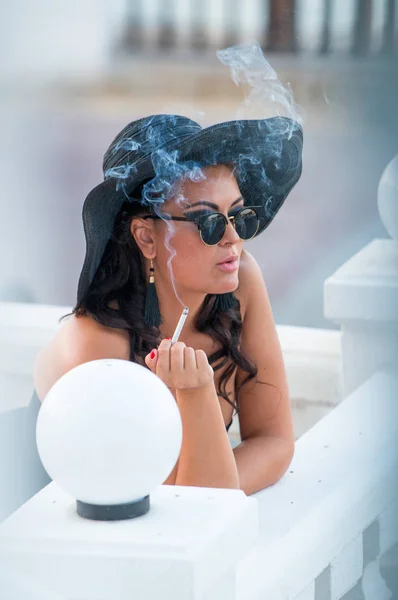 Bir sigara ile şapkalı bir kadın — Stok fotoğraf