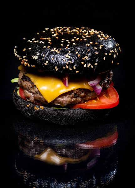 Meat and cheese burger on a black background — Stock Photo, Image