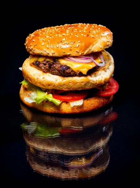 Meat and cheese burger on a black background — Stock Photo, Image