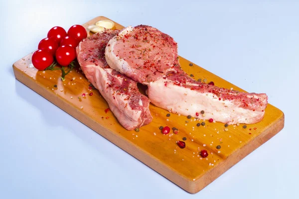 Obearbetat kött och färska grönsaker av nötkött på en träskiva — Stockfoto