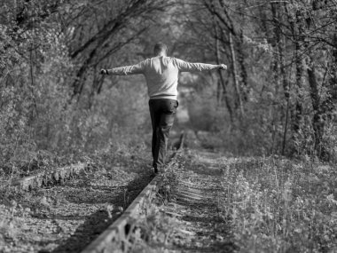 Bir adam raylara çıkar.