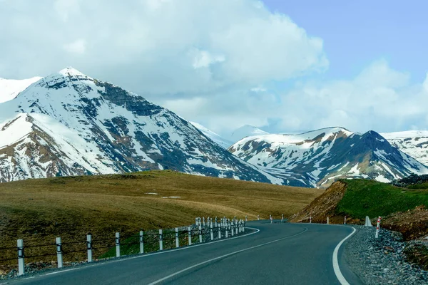 Montañas del Cáucaso y carretera sobre un fondo de nubes azules — Foto de Stock