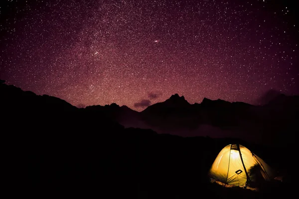 Tenda luminosa tra montagne e stelle — Foto Stock