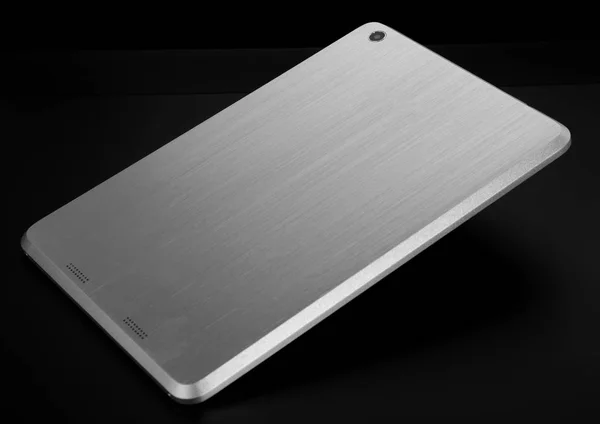 Tablet metal prata branco no fundo preto magro volta plana — Fotografia de Stock