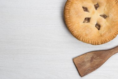 Elmalı turta kek wo kaşık ile ahşap beyaz arka plan üzerinde yalan