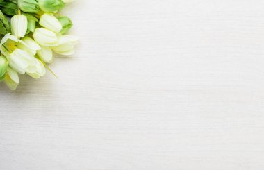 Beyaz ahşap masa arka plan üzerinde yalan bahar laleler