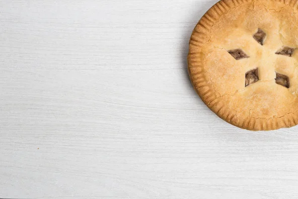 Apple pie cake lying on wooden white background with spoon in wo — Stock Photo, Image