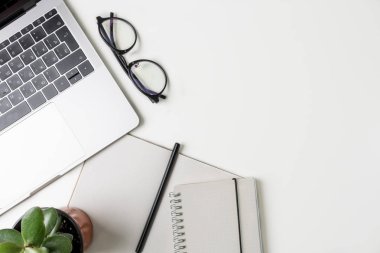 Üstten Görünüm office çalışma alanı'nın. Kopya alanı ile beyaz Masası. Düz yatıyordu manzara laptop, çiçek, defter, kalem ve gözlük ile masada. Yaratıcı tasarımcı kavramı.