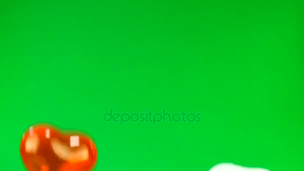赤と白のハートの形で緑色の画面上のバルーン — ストック動画