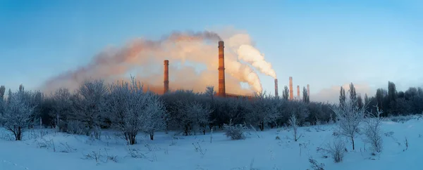 Winter snowy field with chimneys coming out of white smoke. Indu — Stock Photo, Image