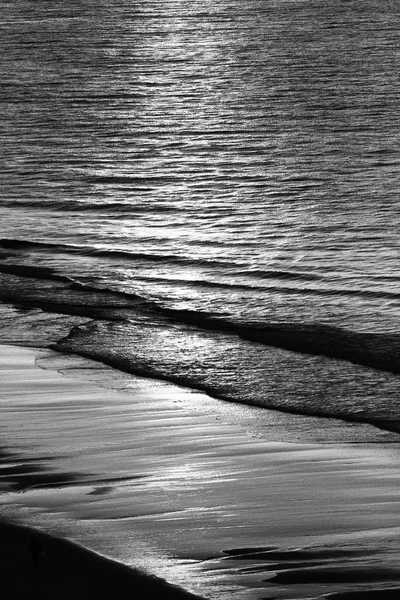 Sunrise over beach in monochrome — Stock Photo, Image