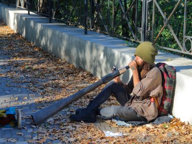 Didgeridoo üzerinde oynarken kukla sokak müzisyen.