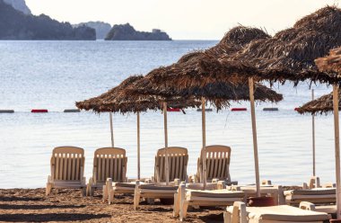 şezlonglar ve şemsiyeler