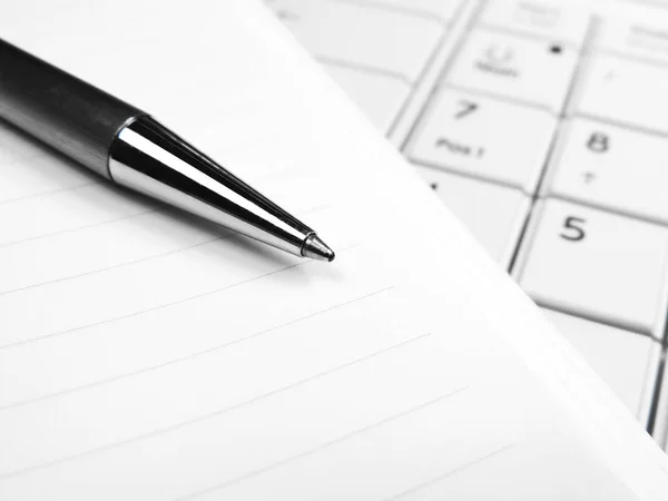 Stylo et papier sur un clavier d'ordinateur portable blanc — Photo