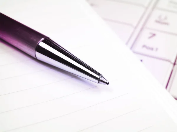 Ручка і папір на білій клавіатурі ноутбука — стокове фото