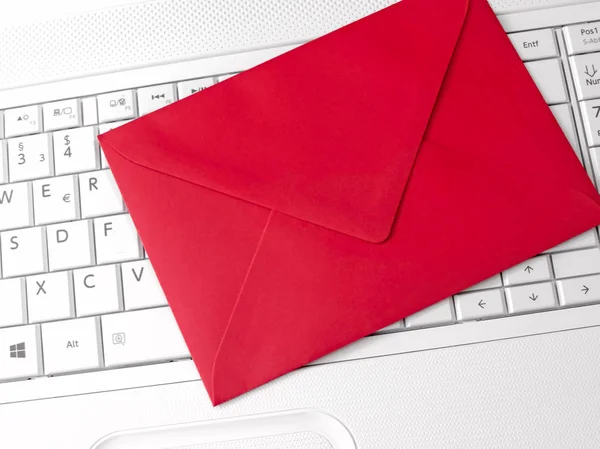 Червоний конверт і біла клавіатура — стокове фото