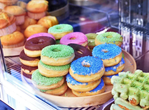 Свежие пончики за витриной магазина — стоковое фото