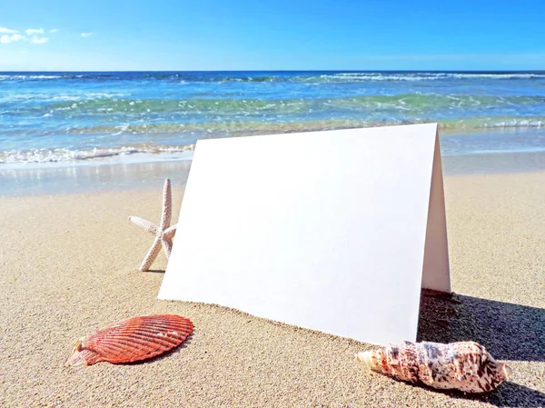 Tarjeta de felicitación blanca y en blanco en la playa —  Fotos de Stock