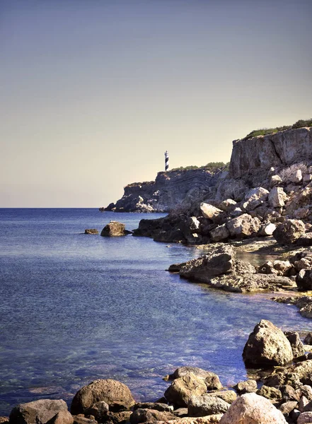 Világítótorony vagy beacon-ra egy szikla tengerpart — Stock Fotó