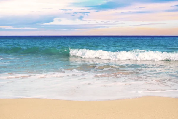 Пляжна сцена на заході сонця з хвилями — стокове фото