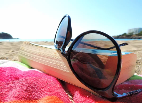 Gafas de sol y libro en la playa —  Fotos de Stock