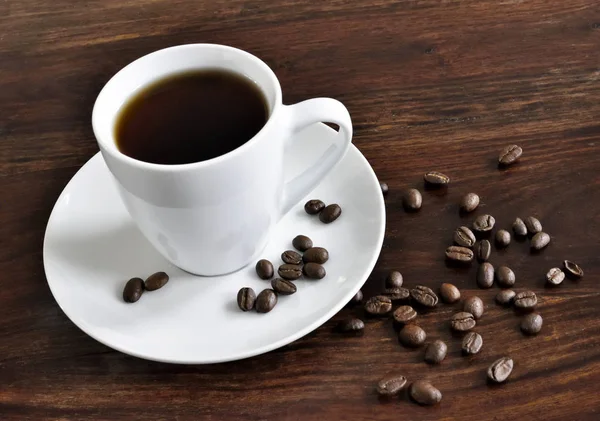 Breakfast scene with coffee cup and coffee beans — Stock Photo, Image