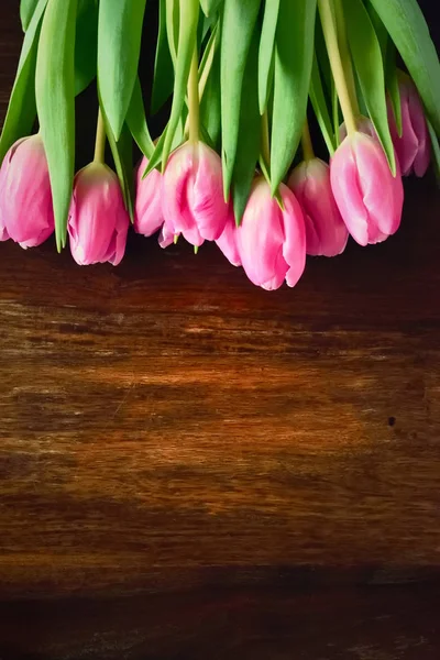 Bouquet de fleurs de tulipes roses sur une table en bois — Photo