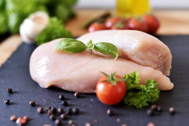 Taze kiraz domates ile kayrak bir plaka üzerinde çiğ tavuk göğsü