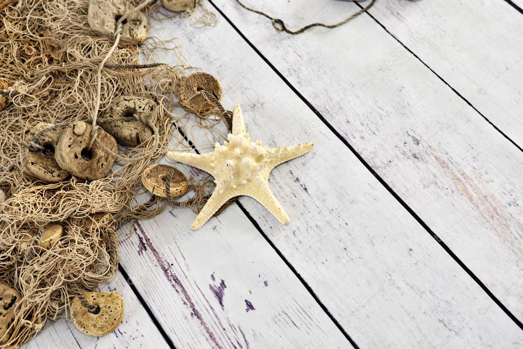 Fishing net or nautical vessel and starfish on wooden planks