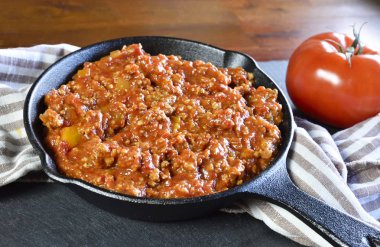 Bolognese sosu bir pişirme pan veya demir tavada. İtalyan mutfağı arka plan ile makarna sosu ve kayrak plaka.