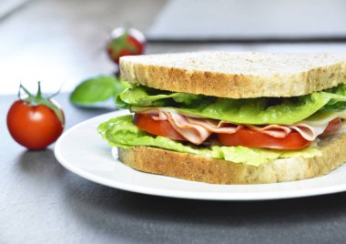 Jambon ve peynir, yakın çekim shot ile kulüp sandviç. Lezzetli Türkiye ve salata sandviç ya da tost domates ve peynir beyaz bir plaka üzerinde.