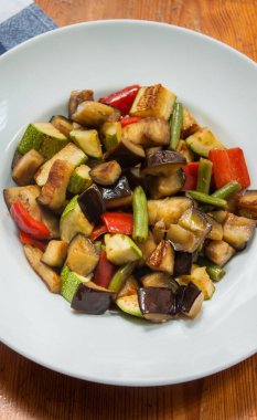 Beyaz tabakta çeşitli sebzeler hazır.