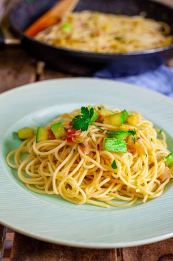 Bir şef makarna pişirmek için sebze ve pastırma hazırlıyor.