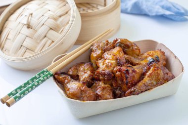 Asya usulü tavuk kanatları kasede servis edilir.