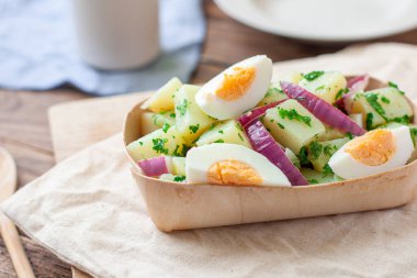 Haşlanmış yumurta ile servis edilen ev yapımı patates salatası.