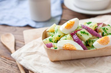 Haşlanmış yumurta ile servis edilen ev yapımı patates salatası.