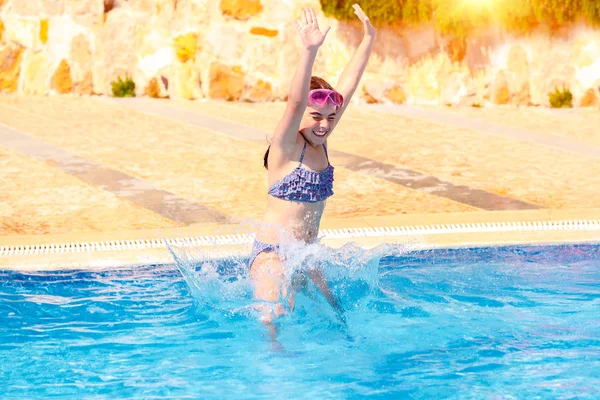 Happy girl jumping to the pool — Stock Photo, Image