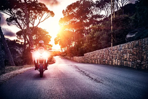 Motorcyklist i solnedgången ljus — Stockfoto