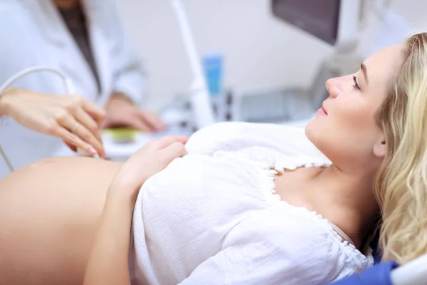 Pregnant woman doing ultrasound scan — Stock Photo, Image