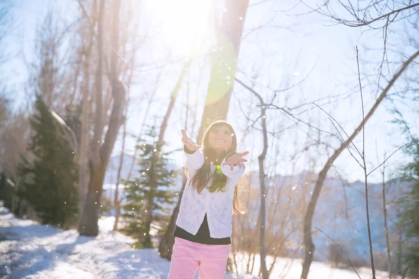 Küçük kız kar taneleri yakalamak — Stok fotoğraf