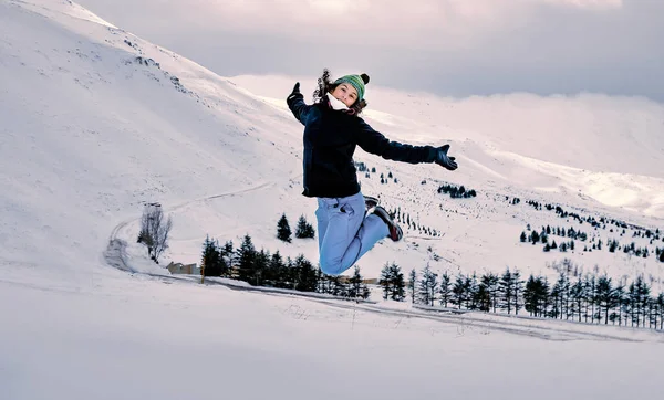 Femme heureuse sautant dans la neige — Photo