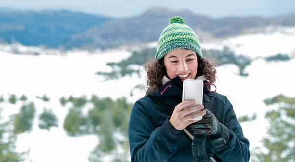 Gelukkige vrouw met behulp van de telefoon in de bergen — Stockfoto