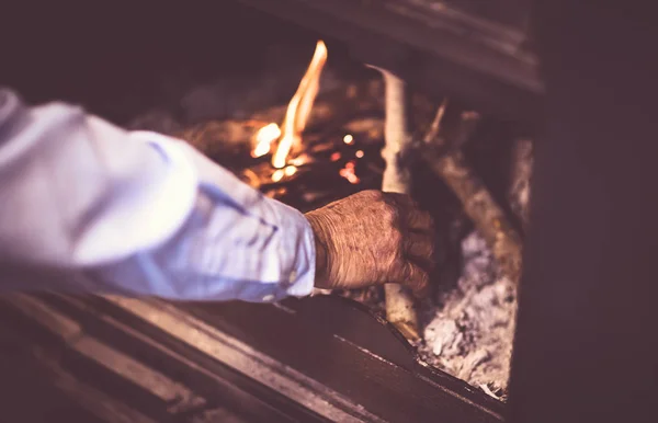 Muž zapalují oheň v krbu — Stock fotografie