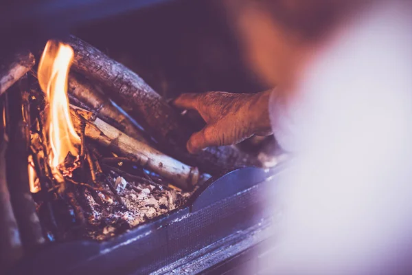 Man kindle a fire in the fireplace — Stock Photo, Image