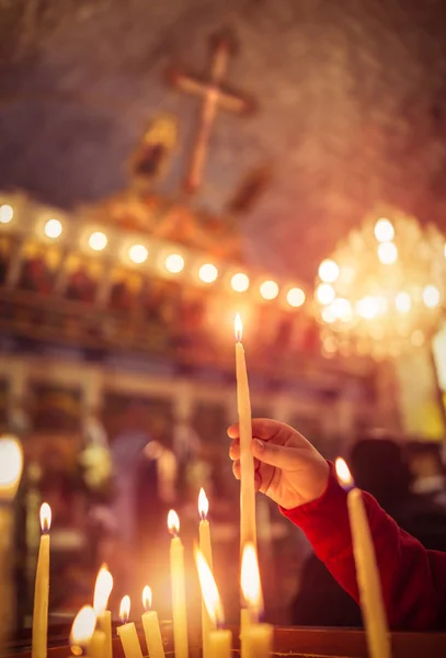 Dítě dává svíčku v kostele — Stock fotografie