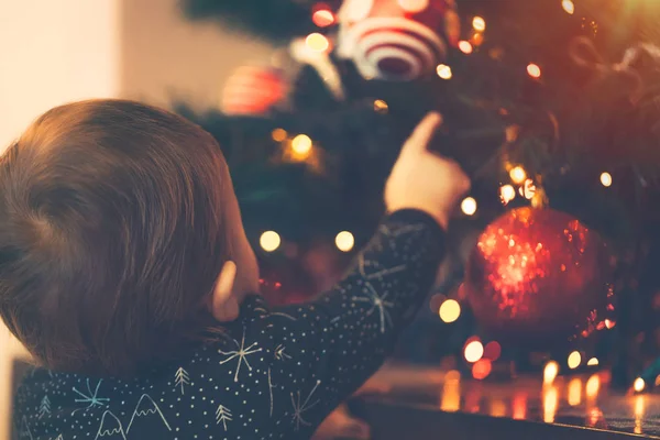 Babyjongen versiert de kerstboom — Stockfoto