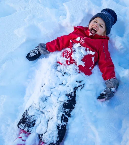 Little girl playing snow angel — 스톡 사진