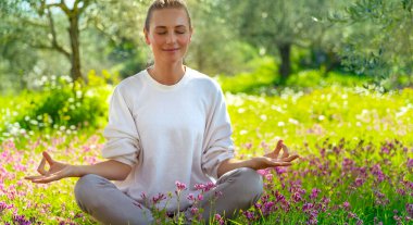 Güzel sakin bir kız, gözleri kapalı, taze çiçek açan bahçede meditasyon yapıyor, doğayla bütünlük, zen dengesi, mutlu ve sağlıklı bir yaşam sürüyor.